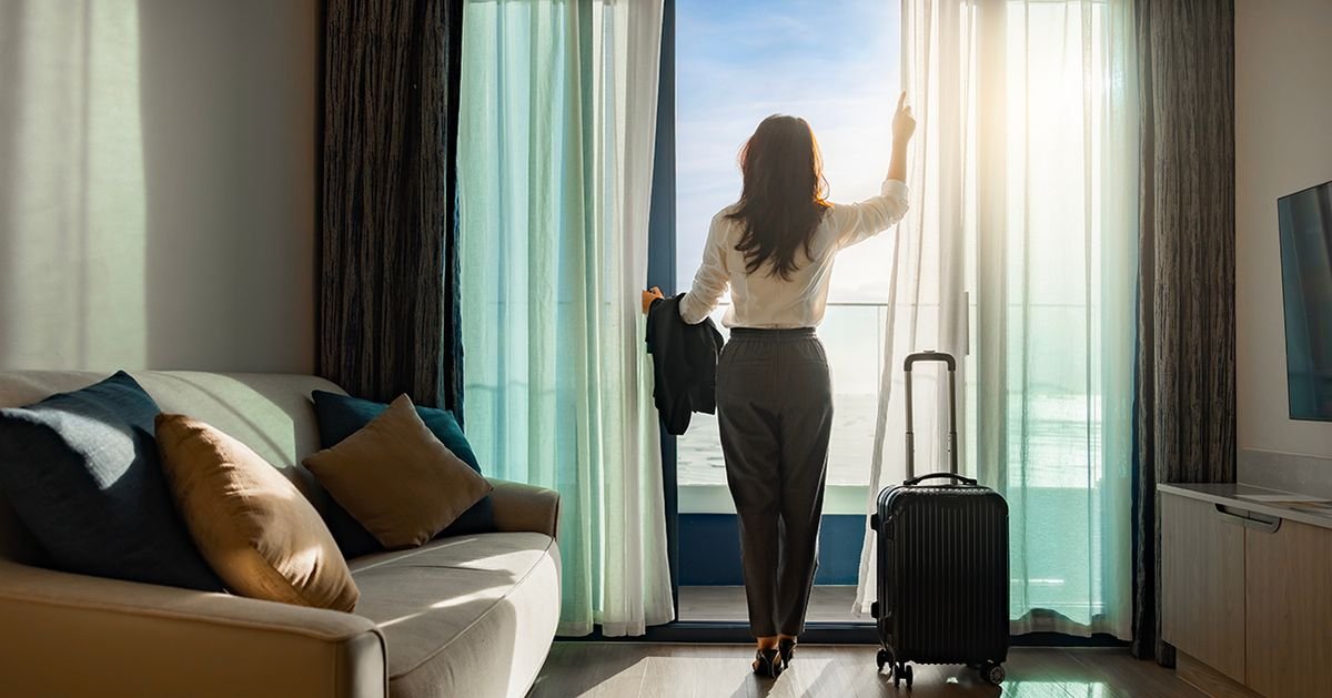 Businesswoman stands in hotel room. Credit / Shutterstock